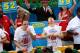 NEW YORK - JULY 4: Joey Chestnut of San Jose, California (C) and Takeru Kobayashi of Nagano, Japan (R) stuff hot dogs into their mouths during Nathan's Famous Fourth of July hot dog eating contest on July 4, 2009 in Coney Island in the Brooklyn borough of New York City. Chestnut defeated Kobayashi with eating 68 to his 64.5 hotdogs. Kobayashi won six previous competitions before tying last year with Chestnut. (Photo by Yana Paskova/Getty Images)