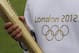 LONDON, ENGLAND - APRIL 18: An Olympic 'torch bearer' holds a London 2012 Olympic torch in Kew Gardens on April 18, 2012 in London, England. Kew Gardens unveiled today a Giant Olympic rings installation made up of at least 20,000 plants and flowers to celebrate one hundred days till the opening ceremony of The London 2012 Olympic Games on July 27 and to announce the official motto as 'Inspire a generation.' (Photo by Oli Scarff/Getty Images)
