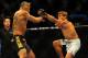 Jul 21, 2012; Calgary, AB, CANADA; Renan Barao (blue golves) and Urijah Faber (red gloves) during the interim bantamweight title bout of UFC 149 at the Scotiabank Saddledome. Mandatory Credit: Anne-Marie Sorvin-US PRESSWIRE