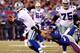 EAST RUTHERFORD, NJ - JANUARY 01: Dave Tollefson #71 of the New York Giants tries to tackle Tony Romo #9 of the Dallas Cowboys at MetLife Stadium on January 1, 2012 in East Rutherford, New Jersey. (Photo by Jeff Zelevansky/Getty Images)