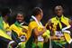 LONDON, ENGLAND - AUGUST 11: Yohan Blake, Usain Bolt, Nesta Carter and Michael Frater of Jamaica celebrate next to the clock after winning gold and setting a new world record of 36.84 during the Men's 4 x 100m Relay Final on Day 15 of the London 2012 Olympic Games at Olympic Stadium on August 11, 2012 in London, England. (Photo by Mike Hewitt/Getty Images)