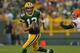 GREEN BAY, WI - AUGUST 16: Aaron Rodgers #12 of the Green Bay Packers rolls out past T.J. Ward #43 of the Cleveland Browns during a preseason game at Lambeau Field on August 16, 2012 in Green Bay, Wisconsin. The Browns defeated the Packers 35-10. (Photo by Jonathan Daniel/Getty Images)