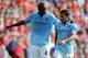 LIVERPOOL, ENGLAND - AUGUST 26: Yaya Toure of Manchester City speaks to team mate Carlos Tevez (R) during the Barclays Premier League match between Liverpool and Manchester City at Anfield on August 26, 2012 in Liverpool, England. (Photo by Michael Regan/Getty Images)