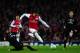 LONDON, ENGLAND - MARCH 06: Alex Oxlade-Chamberlain of Arsenal leaps over the tackle of Mark van Bommel of AC Milan during the UEFA Champions League Round of 16 second leg match between Arsenal and AC Milan at Emirates Stadium on March 6, 2012 in London, England. (Photo by Laurence Griffiths/Getty Images)