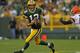 GREEN BAY, WI - AUGUST 16: Aaron Rodgers #12 of the Green Bay Packers rolls out past T.J. Ward #43 of the Cleveland Browns during a preseason game at Lambeau Field on August 16, 2012 in Green Bay, Wisconsin. The Browns defeated the Packers 35-10. (Photo by Jonathan Daniel/Getty Images)