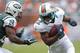 MIAMI GARDENS, FL - SEPTEMBER 23: Reggie Bush #22 of the Miami Dolphins runs with the ball against Darrelle Revis #24 of the New York Jets on September 23, 2012 at Sun Life Stadium in Miami Gardens, Florida. The Jets defeated the Dolphins 23-20 in overtime. (Photo by Joel Auerbach/Getty Images)