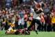 LANDOVER, MD - SEPTEMBER 23: Andrew Hawkins #16 of the Cincinnati Bengals avoids the tackle of Richard Crawford #39 of the Washington Redskins on his way to scoring the game-winning touchdown on a pass from Andy Dalton #14 in the fourth quarter at FedExField on September 23, 2012 in Landover, Maryland. The Cincinnati Bengals defeated the Washington Redskins 38-31. (Photo by Patrick McDermott/Getty Images)