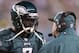 Micahel Vick talks with his offensive coordinator during a game