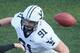 CAMBRIDGE, MA - NOVEMBER 20: Collier Winters #16 of the Harvard Crimson throws a touchdown pass as Joe Young #91 of the Yale Bulldogs defends on November 20, 2010 at Harvard Stadium in Cambridge, Massachusetts. Harvard defeated Yale 28-21. (Photo by Elsa/Getty Images)