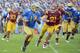 PASADENA, CA - NOVEMBER 17: Brett Hundley #17 of the UCLA Bruins scrambles out of the pocket as he is chased by Morgan Breslin #91 of the USC Trojans during the third quarter at Rose Bowl on November 17, 2012 in Pasadena, California. The UCLA Bruins won 38-28. (Photo by Harry How/Getty Images)