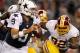 ARLINGTON, TX - NOVEMBER 22: Tony Romo #9 of the Dallas Cowboys looks for an open receiver under pressure from Chris Baker #92 of the Washington Redskins on Thanksgiving Day at Cowboys Stadium on November 22, 2012 in Arlington, Texas. The Washington Redskins beat the Dallas Cowboys 38-31. (Photo by Tom Pennington/Getty Images)