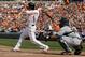 BALTIMORE, MD - APRIL 04: Brian Roberts #1 of the Baltimore Orioles swings at a pitch as catcher Alex Avila #13 of the Detroit Tigers looks on during opening day at Oriole Park at Camden Yards on April 4, 2011 in Baltimore, Maryland. (Photo by Rob Carr/Getty Images)