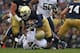 SOUTH BEND, IN - NOVEMBER 03: Cierre Wood #20 of the Notre Dame Fighting Irish is dropped for a loss by Shayne Hale #45 of the Pittsburgh Panthers at Notre Dame Stadium on November 3, 2012 in South Bend, Indiana. Notre Dame defeated Pittsburgh 29-26 in triple overtime. (Photo by Jonathan Daniel/Getty Images)