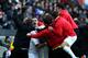 MILTON KEYNES, ENGLAND - DECEMBER 02: Jon Otsemobor of MK Dons is mobbed by team mates as scores their second goal during the FA Cup with Budweiser Second Round match between MK Dons and AFC Wimbledon at StadiumMK on December 2, 2012 in Milton Keynes, England. This match is the first meeting between the two teams following the formation of AFC Wimbledon (the football club formed in 2002 by supporters unhappy with their club's relocation to Milton Keynes) and the MK Dons (which Wimbledon F.C. controversially became). (Photo by Jan Kruger/Getty Images)