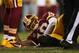 Struggling mightily to lead a comeback late in the fourth quarter, Redskins QB Robert Griffin III went down after reaggravating his already-injured right knee. The 'Skins lost to the Seahawks, 24-14.
