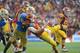 PASADENA, CA - NOVEMBER 17: Matt Barkley #7 of the USC Trojans is hit by Anthony Barr #11 of the UCLA Bruins as he throws during the third quarter at Rose Bowl on November 17, 2012 in Pasadena, California. (Photo by Harry How/Getty Images)