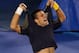 Novak Djokovic rips off his shirt after a five-set victory over Stanislas Wawrinka.