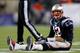 FOXBORO, MA - JANUARY 20: Tom Brady #12 of the New England Patriots sits on the ground after getting knocked down in the fourth quarter against the Baltimore Ravens during the 2013 AFC Championship game at Gillette Stadium on January 20, 2013 in Foxboro, Massachusetts. (Photo by Jim Rogash/Getty Images)