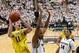 Feb. 12, 2013; East Lansing, MI, USA; Michigan Wolverines guard Nik Stauskas (11) shoots the ball over the top of Michigan State Spartans center Adreian Payne (5) during the second half at Jack Breslin Students Events Center. Mandatory Credit: Mike Carter-USA TODAY Sports