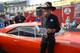 Richard Petty shows off the new Muscle Car stamps in the Daytona FanZone. Credit: Dwight Drum