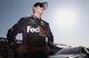FONTANA, CA - MARCH 22: Denny Hamlin, driver of the #11 FedEx Express Toyota, stands on the grid after qualifying for the NASCAR Sprint Cup Series Auto Club 400 at Auto Club Speedway on March 22, 2013 in Fontana, California. (Photo by Jeff Gross/Getty Images)