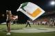 MIAMI - OCTOBER 14: A male Miami Hurricanes cheerleader waves a giant flag while a female cheerleader performs during the game against the Florida International Panthers at the Orange Bowl on October 14, 2006 in Miami, Florida. Miami won 35-0. (Photo by Marc Serota/Getty Images)