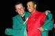 AUGUSTA, GA - APRIL 10: Tiger Woods smiles as he is presented with the green jacket by Phil Mickelson after Woods won The Masters at the Augusta National Golf Club on April 10, 2005 in Augusta, Georgia. (Photo by Harry How/Getty Images)
