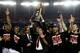 ATLANTA, GA - APRIL 08: Head coach Rick Pitino of the Louisville Cardinals holds up the National Championship trophy as he celebrates with his players including Peyton Siva #3 (R of Pitino after they won 82-76 against the Michigan Wolverines during the 2013 NCAA Men's Final Four Championship at the Georgia Dome on April 8, 2013 in Atlanta, Georgia. (Photo by Streeter Lecka/Getty Images)