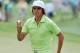 Apr 11, 2013; Augusta, GA, USA; Rickie Fowler waves to the gallery after making a putt on the 18th green and completing the first round of the 2013 The Masters golf tournament at Augusta National Golf Club. Mandatory Credit: Michael Madrid-USA TODAY Sports