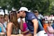 Aug 7, 2011; Akron, OH, USA; Jason Day (right) gives wife Ellie Day (left) a kiss after playing his tee shot on the first hole during the final round of the World Golf Championships Bridgestone Invitational at Firestone Country Club. Mandatory Credit: Allan Henry-USA TODAY Sports