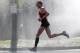 April 16, 2012; Newton, MA, USA; Jason Hartmann (USA) runs thorough water spray near the 19 mile marker during the 2012 Boston Marathon. Mandatory Credit: Greg M. Cooper-USA TODAY Sports
