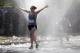April 16, 2012; Newton, MA, USA, Sarah Pociask raises her arms as she runs through a water spray near the 19 mile marker during the 2012 Boston Marathon. Mandatory Credit: Greg M. Cooper-USA TODAY Sports