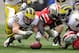 COLUMBUS, OH - NOVEMBER 24: Desmond Morgan #48 of the Michigan Wolverines and Corey Brown #3 of the Ohio State Buckeyes dive for a fumble at Ohio Stadium on November 24, 2012 in Columbus, Ohio. (Photo by Jamie Sabau/Getty Images)