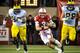 LINCOLN, NE - OCTOBER 27: Quarterback Taylor Martinez #3 of the Nebraska Cornhuskers runs past defensive tackle Ondre Pipkins #56 and defensive end Craig Roh #88 of the Michigan Wolverines during their game at Memorial Stadium on October 27, 2012 in Lincoln, Nebraska. Nebraska beat Michigan 23-9. (Photo by Eric Francis/Getty Images)