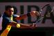 PARIS, FRANCE - JUNE 04: Jo-Wilfried Tsonga of France plays a backhand in his Men's Singles quarter final match against Roger Federer of Switzerland during day ten of the French Open at Roland Garros on June 4, 2013 in Paris, France. (Photo by Clive Brunskill/Getty Images)