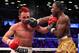 Jun 22, 2013; Brooklyn, NY, USA; Adrien Broner (Gold trunks) and Paulie Malignaggi (White trunks) trade punches during their 12 round WBA welterweight championship bout at the Barclay's Center. Mandatory Credit: Ed Mulholland-USA TODAY Sports