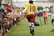 Jul 30, 2013; Richmond, VA, USA; Washington Redskins quarterback Robert Griffin III (10) runs down the sidelines while shaking hands with fans prior to afternoon practice as part of the 2013 NFL training camp at the Bon Secours Washington Redskins Training Center. Mandatory Credit: Geoff Burke-USA TODAY Sports