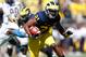 ANN ARBOR, MI - SEPTEMBER 14: Jeremy Gallon #21 of the Michigan Wolverines tries to get around the tackle of Johnny Robinson #4 of the Akron Zips after a second quarter catch at Michigan Stadium on September 14, 2013 in Ann Arbor, Michigan. (Photo by Gregory Shamus/Getty Images)