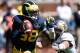 ANN ARBOR, MI - SEPTEMBER 14: Devin Gardner #98 of the Michigan Wolverines scrabbles away for the tackle of Nick Rossi #44 of the Akron Zips during the fourth quarter at Michigan Stadium on September 14, 2013 in Ann Arbor, Michigan. Michigan on the game 28-24. (Photo by Gregory Shamus/Getty Images)