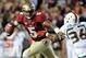 Nov 2, 2013; Tallahassee, FL, USA; Florida State Seminoles quarterback Jameis Winston (5) evades Miami Hurricanes linebacker Alex Figueroa (36) during the second half at Doak Campbell Stadium. Mandatory Credit: Melina Vastola-USA TODAY Sports