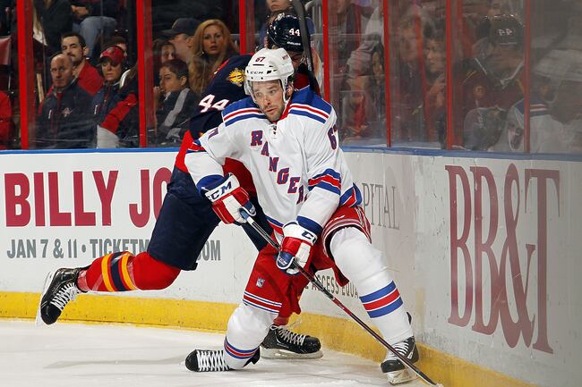 Hi-res-452305969-benoit-pouliot-of-the-new-york-rangers-digs-the-puck_crop_north