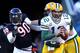 CHICAGO, IL - JANUARY 23: Quarterback Aaron Rodgers #12 of the Green Bay Packers runs the ball ahead of Julius Peppers #90 of the Chicago Bears in the NFC Championship Game at Soldier Field on January 23, 2011 in Chicago, Illinois. (Photo by Andy Lyons/Getty Images)