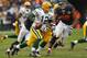 CHICAGO, IL - DECEMBER 16: Aaron Rodgers #12 of the Green Bay Packers rolls out to look for a receiver chased by Cory Wootton #98 of the Chicago Bears at Soldier Field on December 16, 2012 in Chicago, Illinois. The Packers defeated the Bears 21-13. (Photo by Jonathan Daniel/Getty Images)