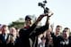 Tiger Woods holds up the trophy after winning the Farmers Insurance Open golf tournament at the Torrey Pines Golf Course, Monday, Jan. 28, 2013, in San Diego. Woods closed with an even-par 72 for a four-shot victory. (AP Photo/Gregory Bull)