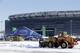 Tractors plow snow off the parking lot of MetLife Stadium near a tent which will serve as an access point into Super Bowl XLVIII as crews removed snow following a snow storm, Wednesday, Jan. 22, 2014, in East Rutherford, N.J. Super Bowl XLVIII, which will be played between the Denver Broncos and the Seattle Seahawks on Feb. 2, will be the first NFL title game held outdoors in a city where it snows. (AP Photo/Julio Cortez)