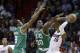 Miami Heat point guard Mario Chalmers (15) prepares to pass as Boston Celtics power forward Brandon Bass (30) and point guard Rajon Rondo (9) defend during the fourth quarter of an NBA basketball game in Miami, Tuesday, Jan. 21, 2014. The Heat won 93-86. (AP Photo/Alan Diaz)