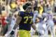 Michigan offensive linesman Taylor Lewan (77) walks back to the bench as the Ohio State team celebrates in the closing seconds of their NCAA college football game in Ann Arbor, Mich., Saturday, Nov. 30, 2013. Ohio State defeated Michigan 42-41. (AP Photo/Carlos Osorio)