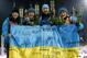 Ukraine's relay team Vita Semerenko, Juliya Dzhyma, Olena Pidhrushna and Valj Semerenko, from left, celebrate with a Ukrainian flag with writings on it after winning the gold during the women's biathlon 4x6k relay, at the 2014 Winter Olympics, Friday, Feb. 21, 2014, in Krasnaya Polyana, Russia. (AP Photo/Dmitry Lovetsky)