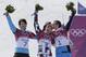 Men's snowboard parallel slalom gold medalist Vic Wild of Russia, center, is kissed by bronze medalist Benjamin Karl, right, as silver medalist Zan Kosir of Slovenia, left, celebrates, at the Rosa Khutor Extreme Park, at the 2014 Winter Olympics, Saturday, Feb. 22, 2014, in Krasnaya Polyana, Russia. (AP Photo/Andy Wong)