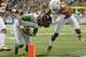 Oregon's Marcus Mariota (8) is pulled down by his helmet by Texas' Mykkele Thompson (2) during the first quarter in the Valero Alamo Bowl NCAA college football game, Monday, Dec. 30, 2013, in San Antonio. (AP Photo/Eric Gay)